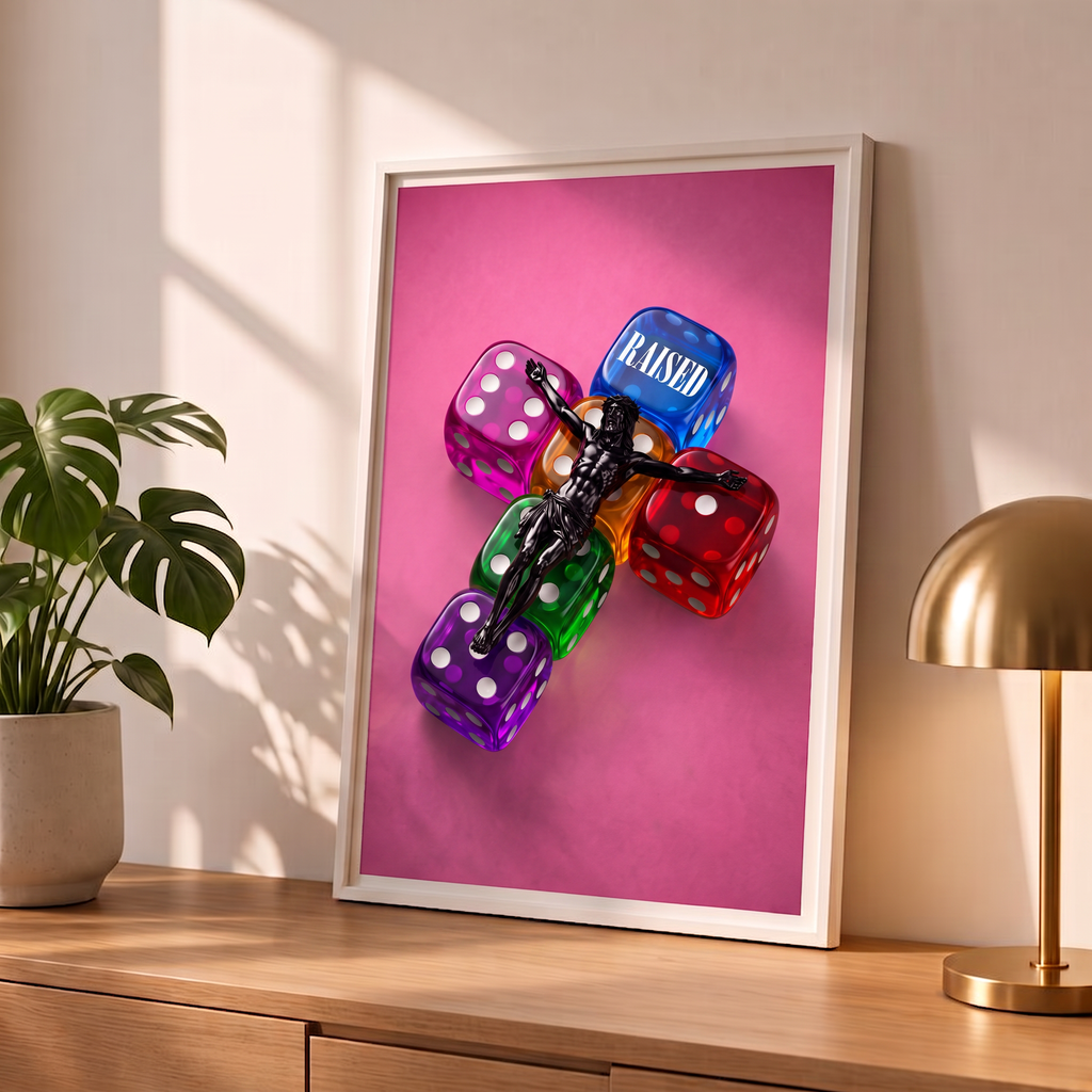 RAISED pink Jesus poster in a styled tabletop mockup beside a plant and brass-colored lamp.