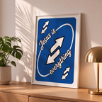 Jesus Is Everything blue Christian poster in a styled tabletop mockup beside a plant and brass-colored lamp.