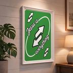 Jesus Is Everything green Christian poster displayed in a white frame on a paneled wall beside a plant and lamp.