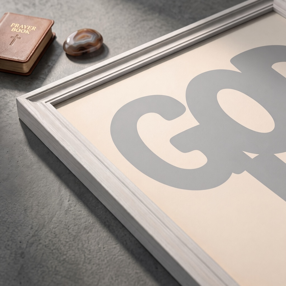 Angled close-up of the God Is Good grey poster showing rounded lettering on a cream background.